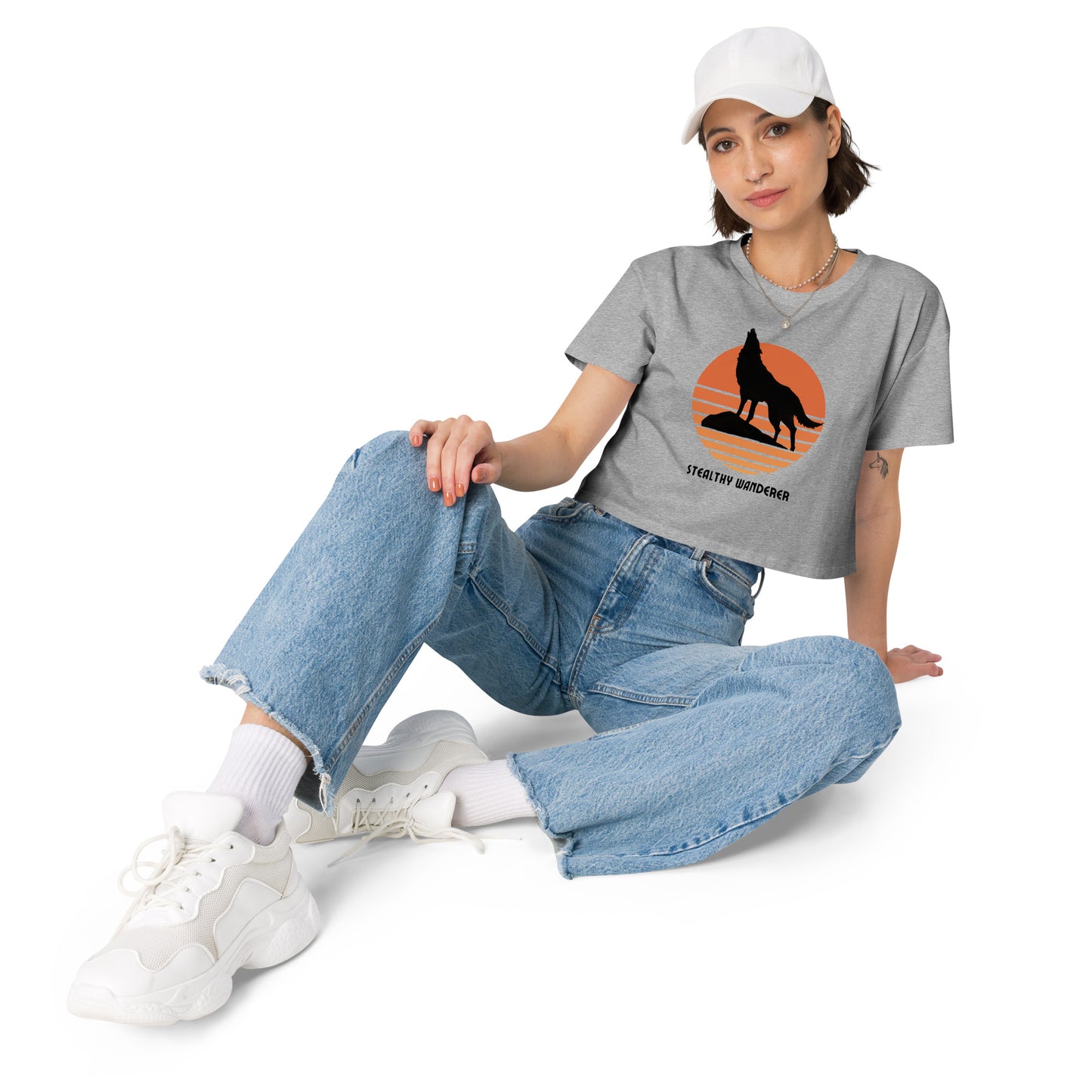 Relaxed woman in a grey crop top with a bold silhouette graphic design, embodying a modern artistic flair and personal expression.