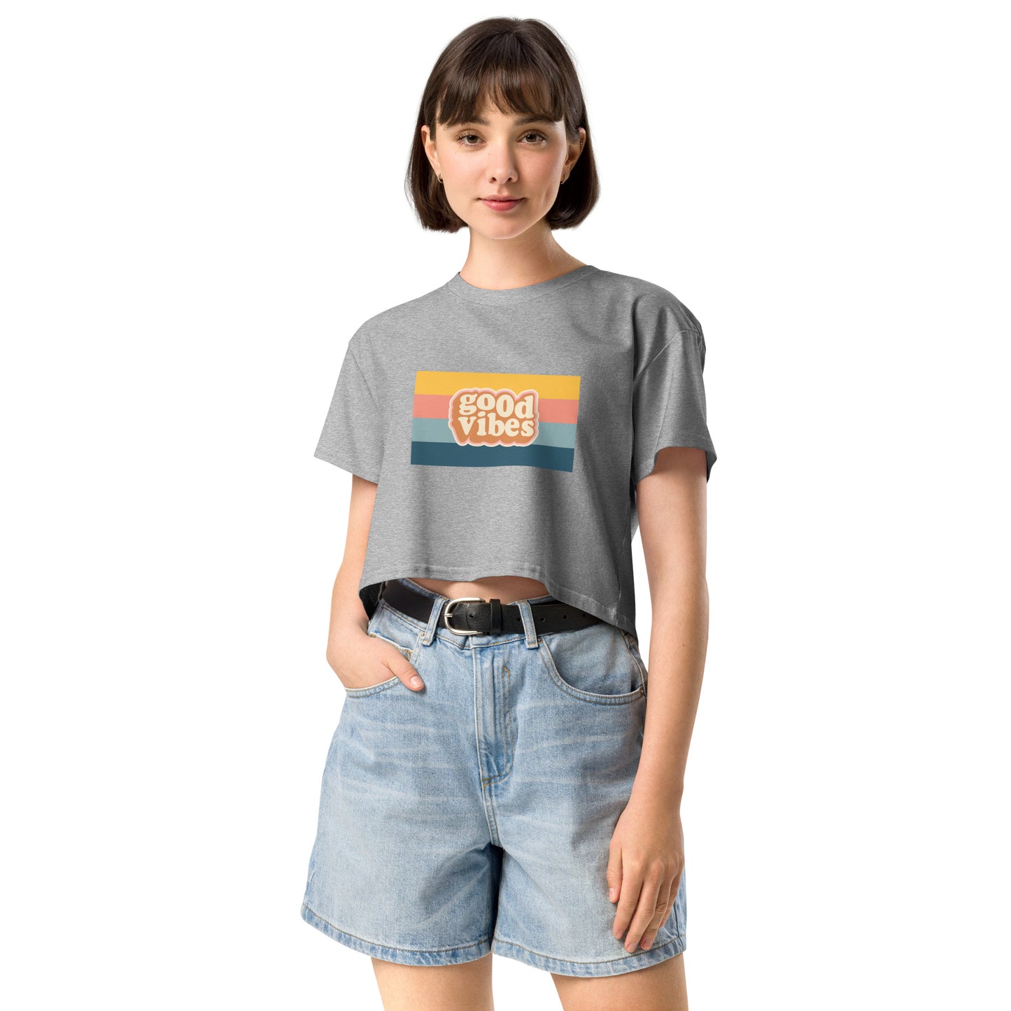 Woman in a grey empowering retro crop top with 'Good Vibes' graphic