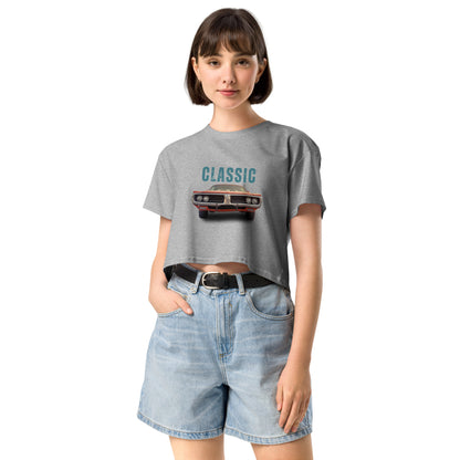 Young woman sporting a grey crop top with a classic car graphic design and 'CLASSIC' text, paired with blue denim shorts for a relaxed yet fashionable look.