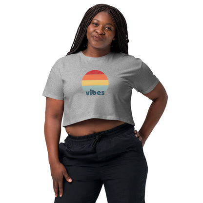 Woman wearing a grey crop top with a colorful retro sunset design, offering a chic throwback style for a casual, expressive look.