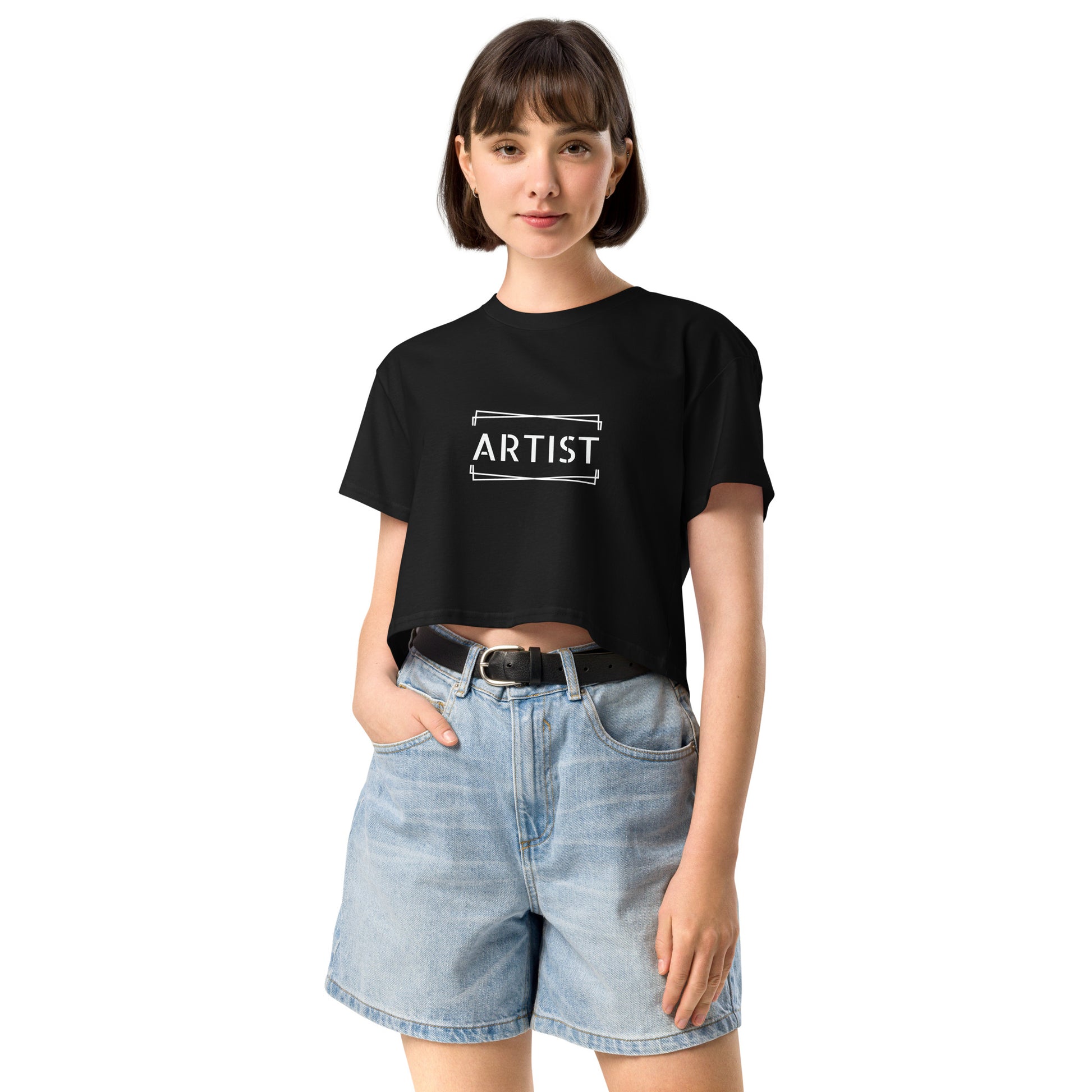 Confident young woman in a black empowering crop top with the word 'ARTIST' printed in white.