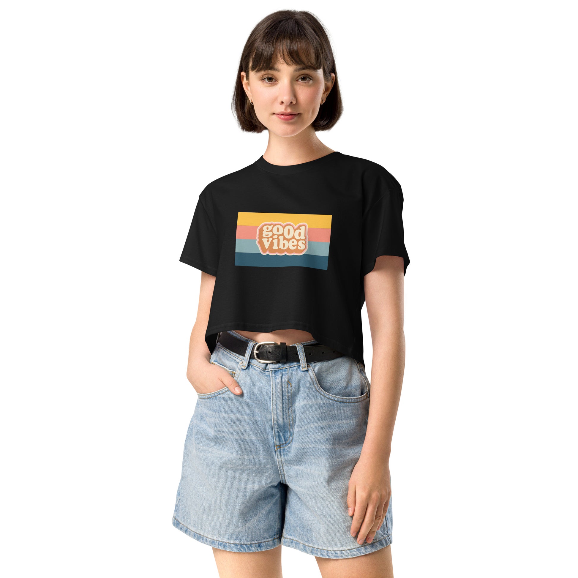 Woman in a black empowering retro crop top with 'Good Vibes' graphic