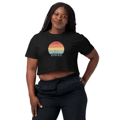 Woman wearing a black crop top with a colorful retro sunset design, offering a chic throwback style for a casual, expressive look.