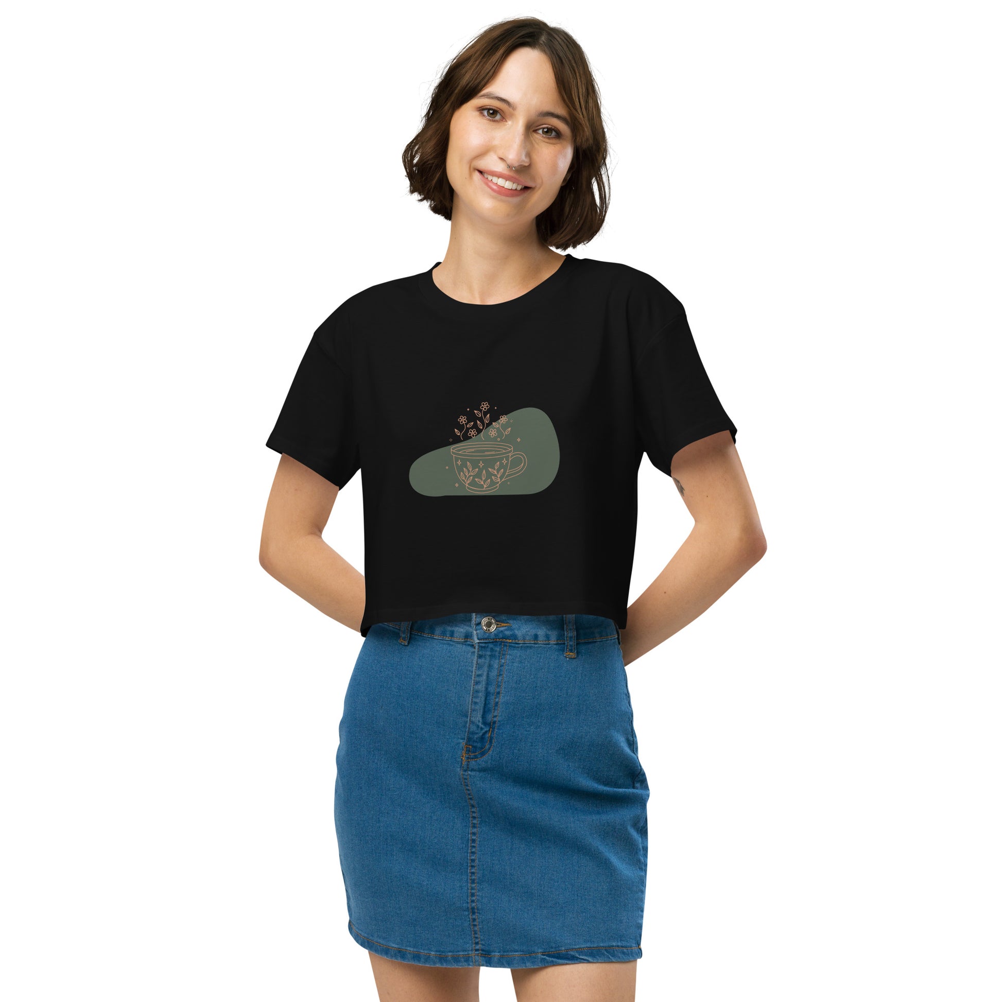 Woman wearing a black loose-fit crop top with a floral coffee cup graphic design, embodying comfortable and authentic fashion by BYOL.