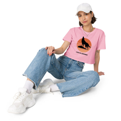 Relaxed woman in a bubblegum pink crop top with a bold silhouette graphic design, embodying a modern artistic flair and personal expression.