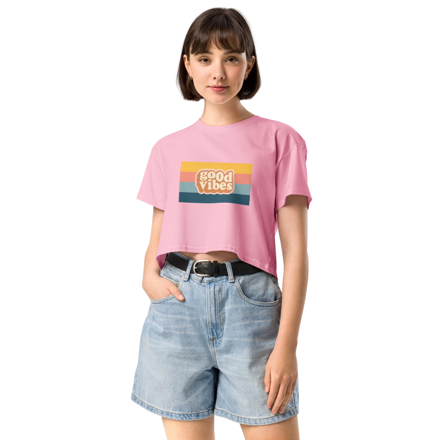 Woman in a bubblegum pink empowering retro crop top with 'Good Vibes' graphic