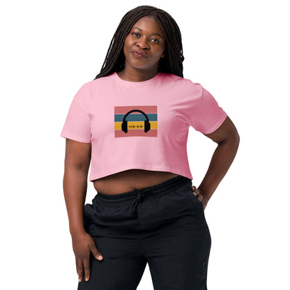 Confident woman wearing a bubblegum crop top with colorful headphone graphic design.