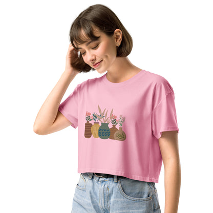 Woman wearing a bubblegum pink loose-fit crop top with a charming vase floral graphic design, embodying comfortable and authentic fashion by BYOL.