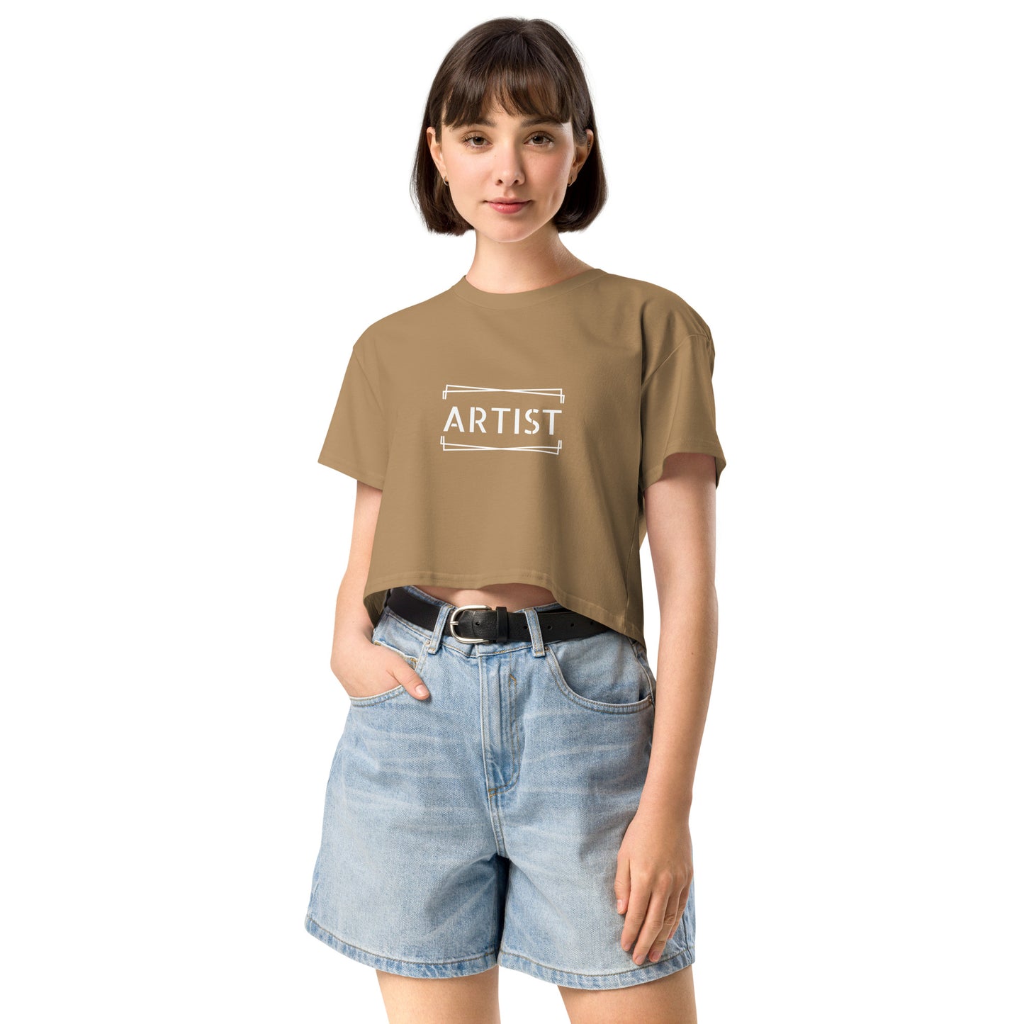 Confident young woman in a camel empowering crop top with the word 'ARTIST' printed in white.