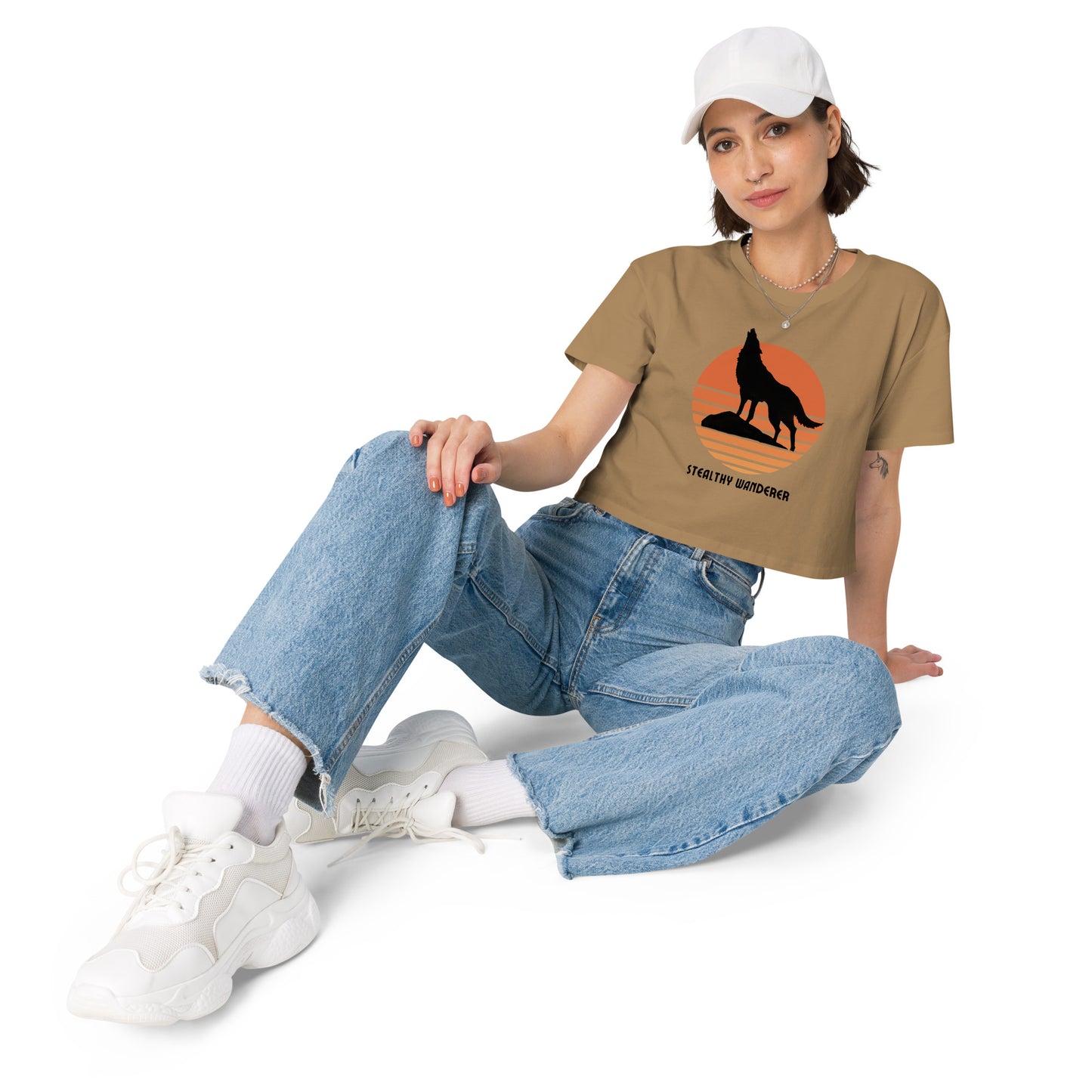 Relaxed woman in a camel crop top with a bold silhouette graphic design, embodying a modern artistic flair and personal expression.