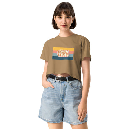 Woman in a camel empowering retro crop top with 'Good Vibes' graphic