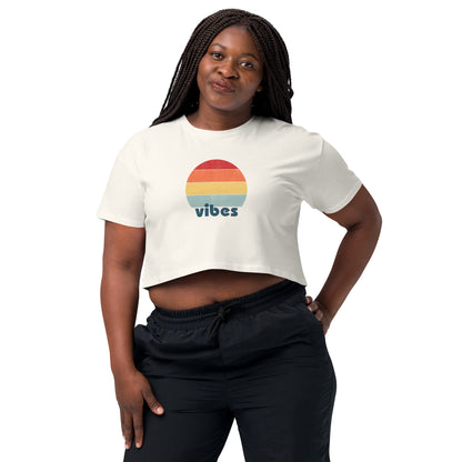 Woman wearing a ecru crop top with a colorful retro sunset design, offering a chic throwback style for a casual, expressive look.