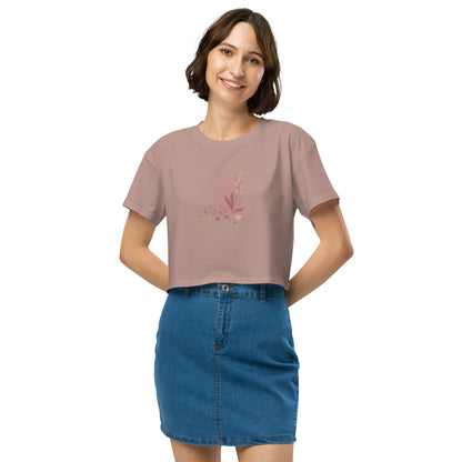 Woman wearing a hazy pink colored loose-fit crop top with a subtle muted graphic design, showcasing comfortable and authentic fashion by BYOL. 