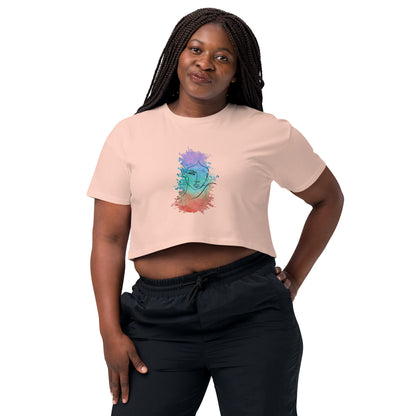 Woman in a pale pink crop top with a colorful cosmic design expressing artistic individuality