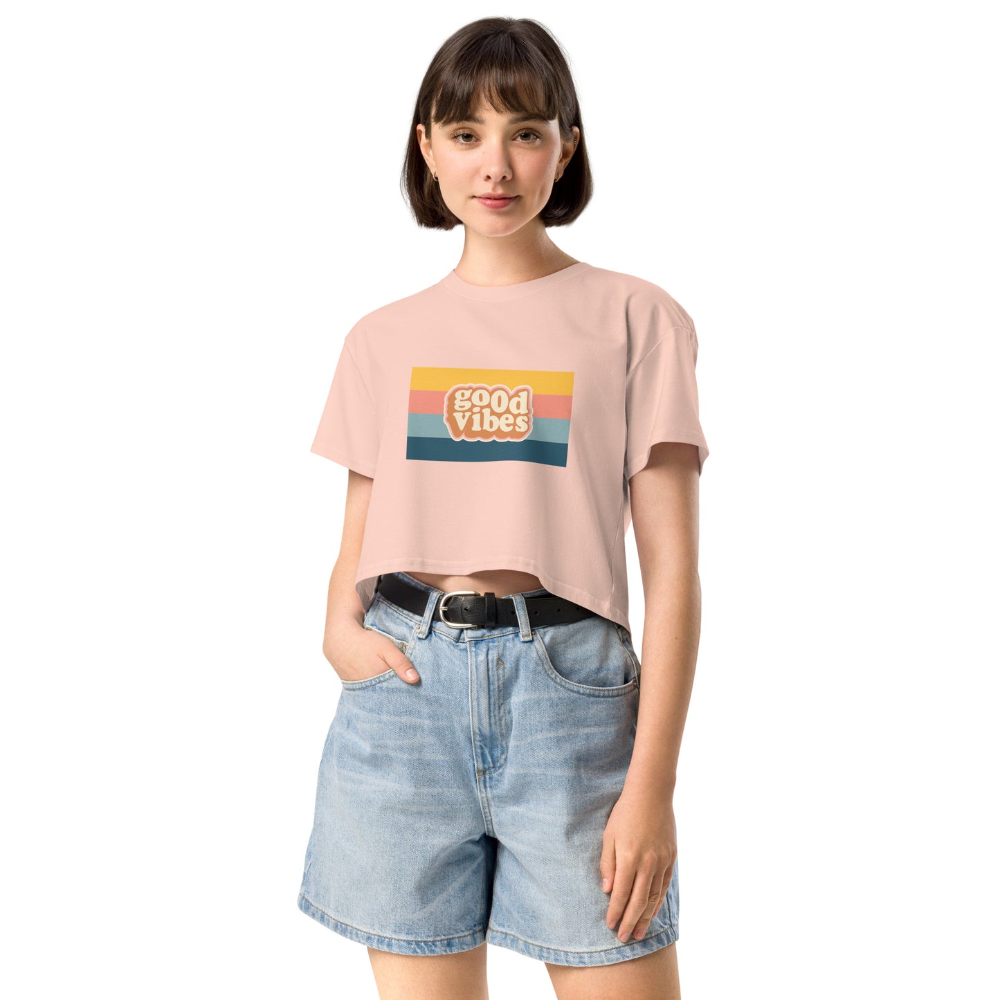 Woman in a pale pink empowering retro crop top with 'Good Vibes' graphic