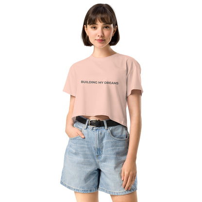 Women’s pale pink Loose-Fit Crop Top with "Building my dreams" slogan in various colors and sizes, XS to XL.