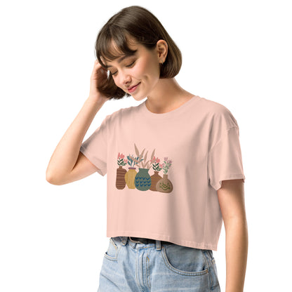 Woman wearing a pale pink loose-fit crop top with a charming vase floral graphic design, embodying comfortable and authentic fashion by BYOL.