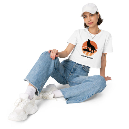 Relaxed woman in a white crop top with a bold silhouette graphic design, embodying a modern artistic flair and personal expression.