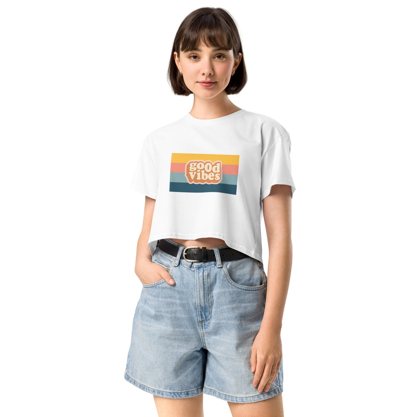 Woman in a white empowering retro crop top with 'Good Vibes' graphic