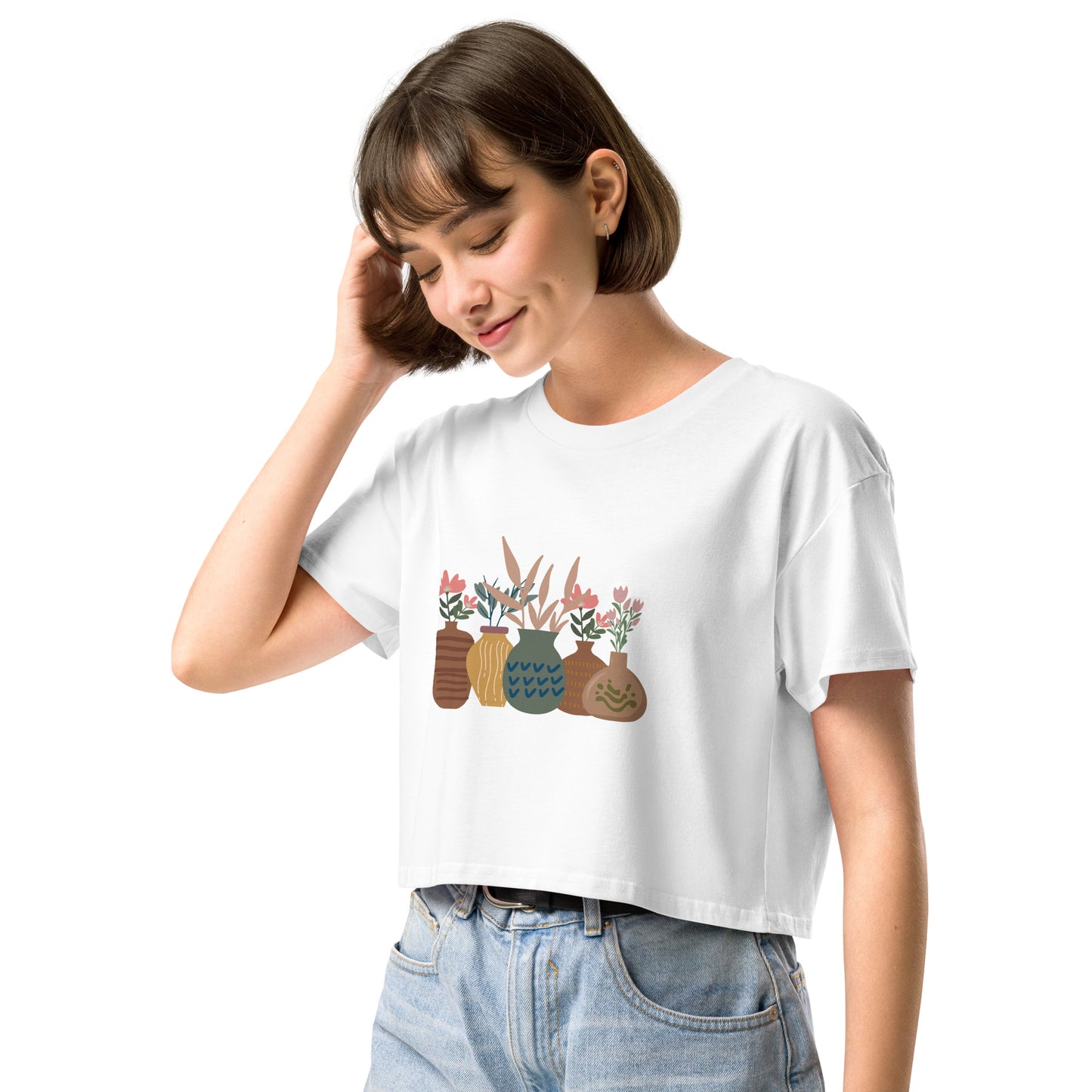 Woman wearing a white loose-fit crop top with a charming vase floral graphic design, embodying comfortable and authentic fashion by BYOL.