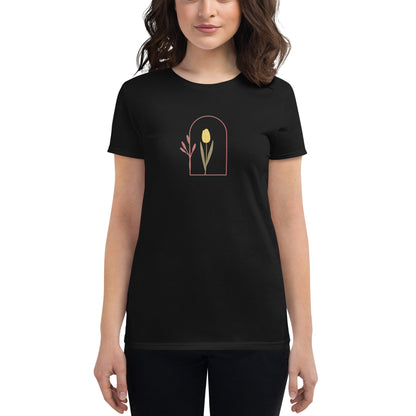 Woman wearing a black fitted tee with a delicate tulip arch design, showcasing subtle elegance and nature-inspired style by BYOL.