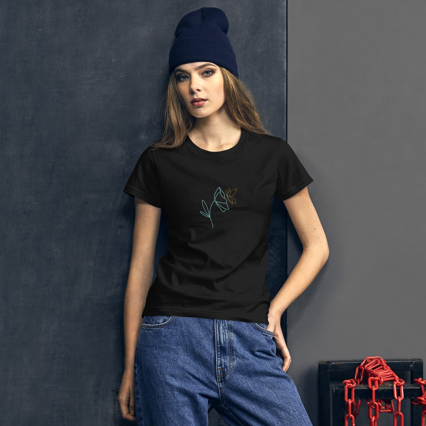 Woman wearing a black fitted tee with a delicate flower design in blue and yellow, embodying subtle self-expression and style by BYOL.