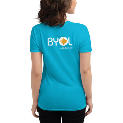 Back view of a woman wearing a carribean blue BYOL mindset t-shirt with color options in black, red, blue, gray, and white, available in sizes S to 3XL.