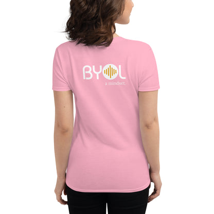 Back view of a woman wearing a charity pink BYOL mindset t-shirt with color options in black, red, blue, gray, and white, available in sizes S to 3XL.