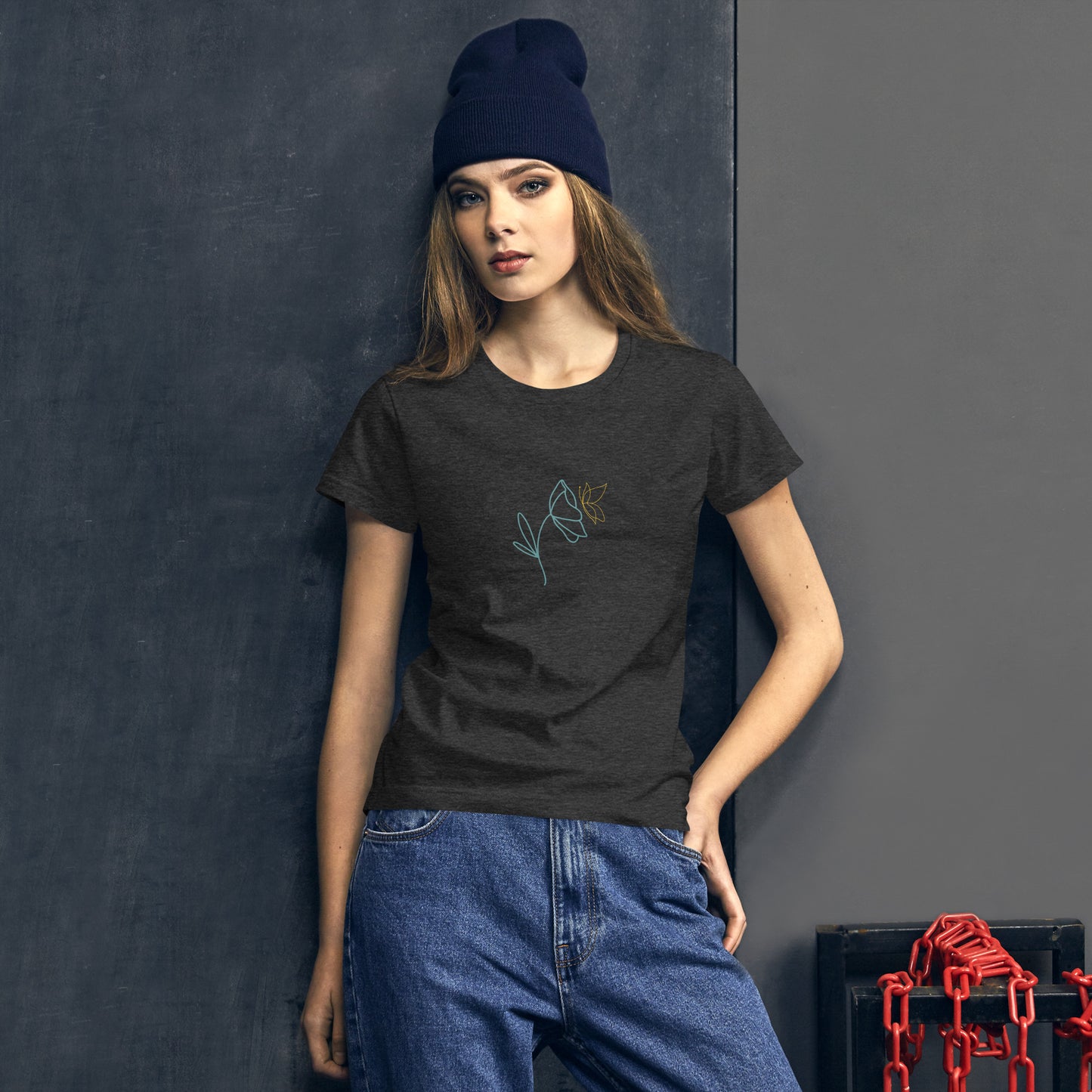 Woman wearing a dark heather grey fitted tee with a delicate flower design in blue and yellow, embodying subtle self-expression and style by BYOL.