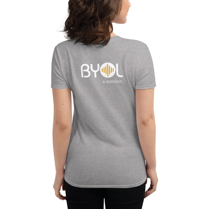 Back view of a woman wearing a heather grey BYOL mindset t-shirt with color options in black, red, blue, gray, and white, available in sizes S to 3XL.