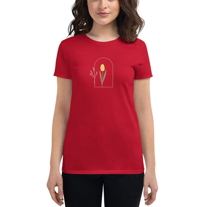 Woman wearing a true red fitted tee with a delicate tulip arch design, showcasing subtle elegance and nature-inspired style by BYOL.