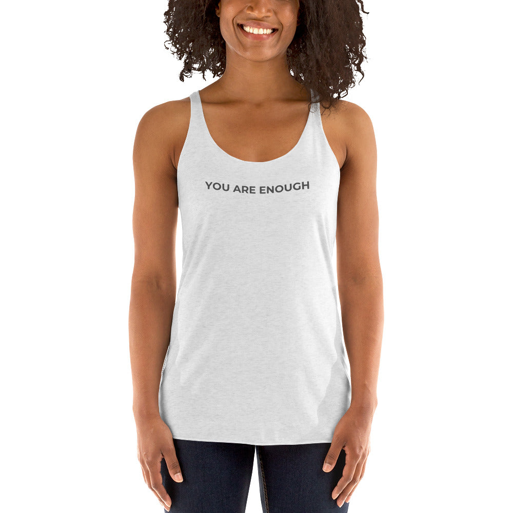 Smiling woman wearing a heather white racer back tank with "You Are Enough" text.