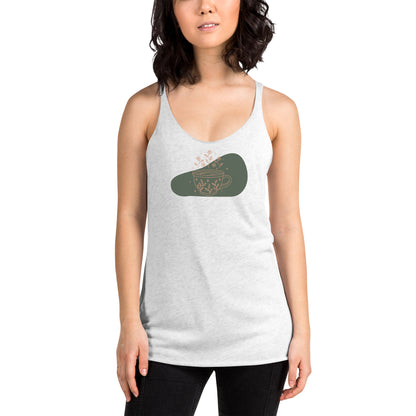 Woman wearing a heather white racer back tank top with a muted coffee cup and floral design.