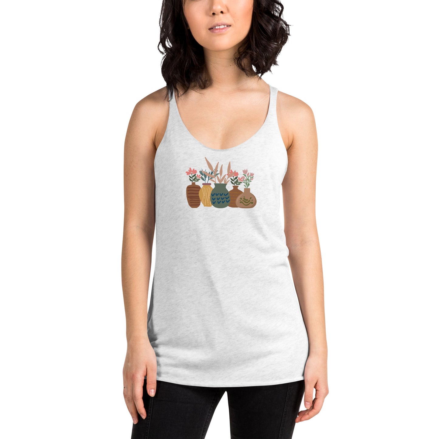 Woman wearing a heather white racer back tank top with a subtle design of various pots and plants.