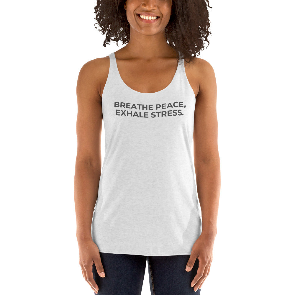 Smiling woman in a heather white racer back tank with "Breathe Peace, Exhale Stress" text.