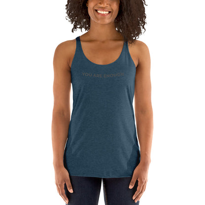 Smiling woman wearing a indigo racer back tank with "You Are Enough" text.