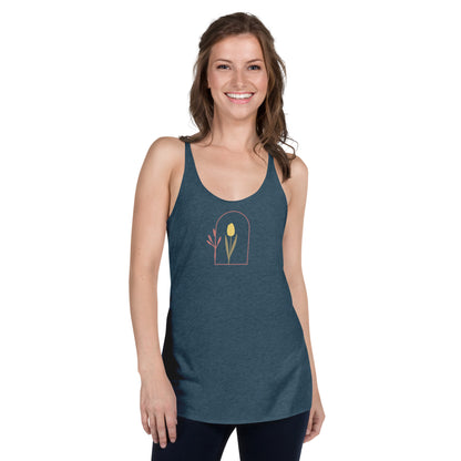 Woman wearing a heather indigo racer back tank top with a subtle single flower design.