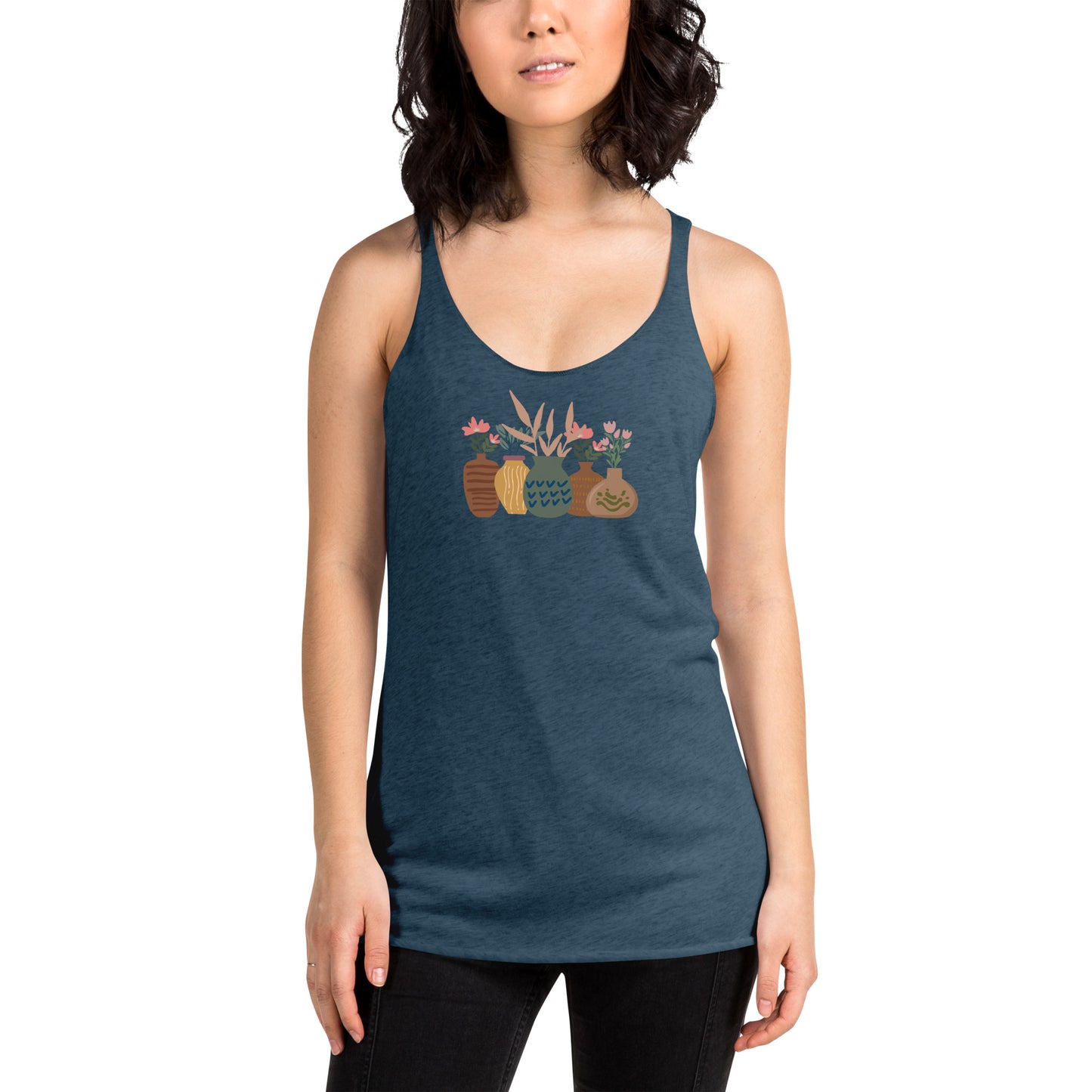 Woman wearing a heather blue racer back tank top with a subtle design of various pots and plants.