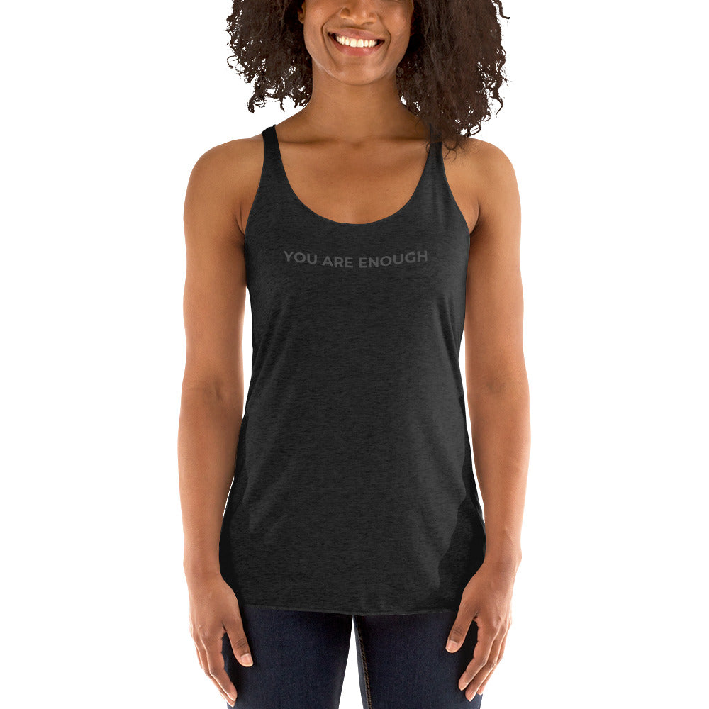 Smiling woman wearing a heather dark grey racer back tank with "You Are Enough" text.