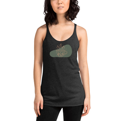 Woman wearing a heather grey racer back tank top with a muted coffee cup and floral design.