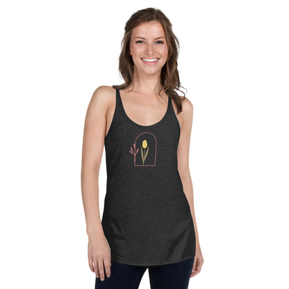 Woman wearing a heather grey racer back tank top with a subtle single flower design.