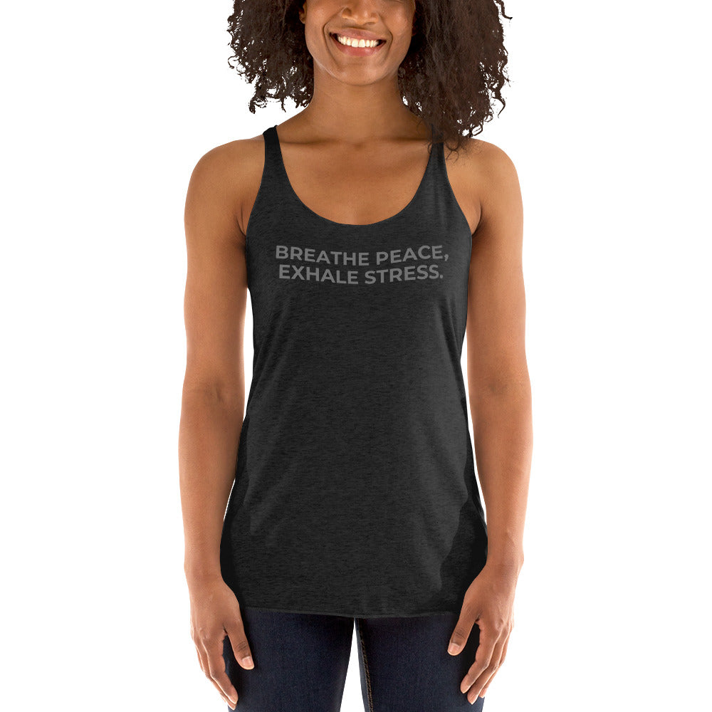 Smiling woman in a heather dark grey racer back tank with "Breathe Peace, Exhale Stress" text.