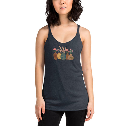 Woman wearing a heather indigo racer back tank top with a subtle design of various pots and plants.