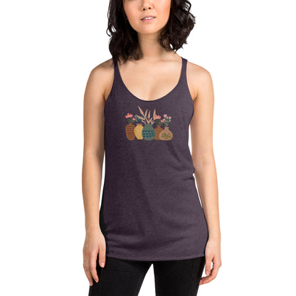 Woman wearing a heather purple racer back tank top with a subtle design of various pots and plants.