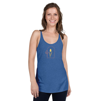 Woman wearing a heather blue racer back tank top with a subtle single flower design.