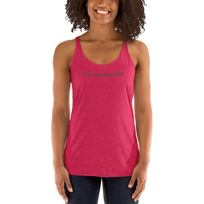 Smiling woman wearing a shocking pink racer back tank with "You Are Enough" text.