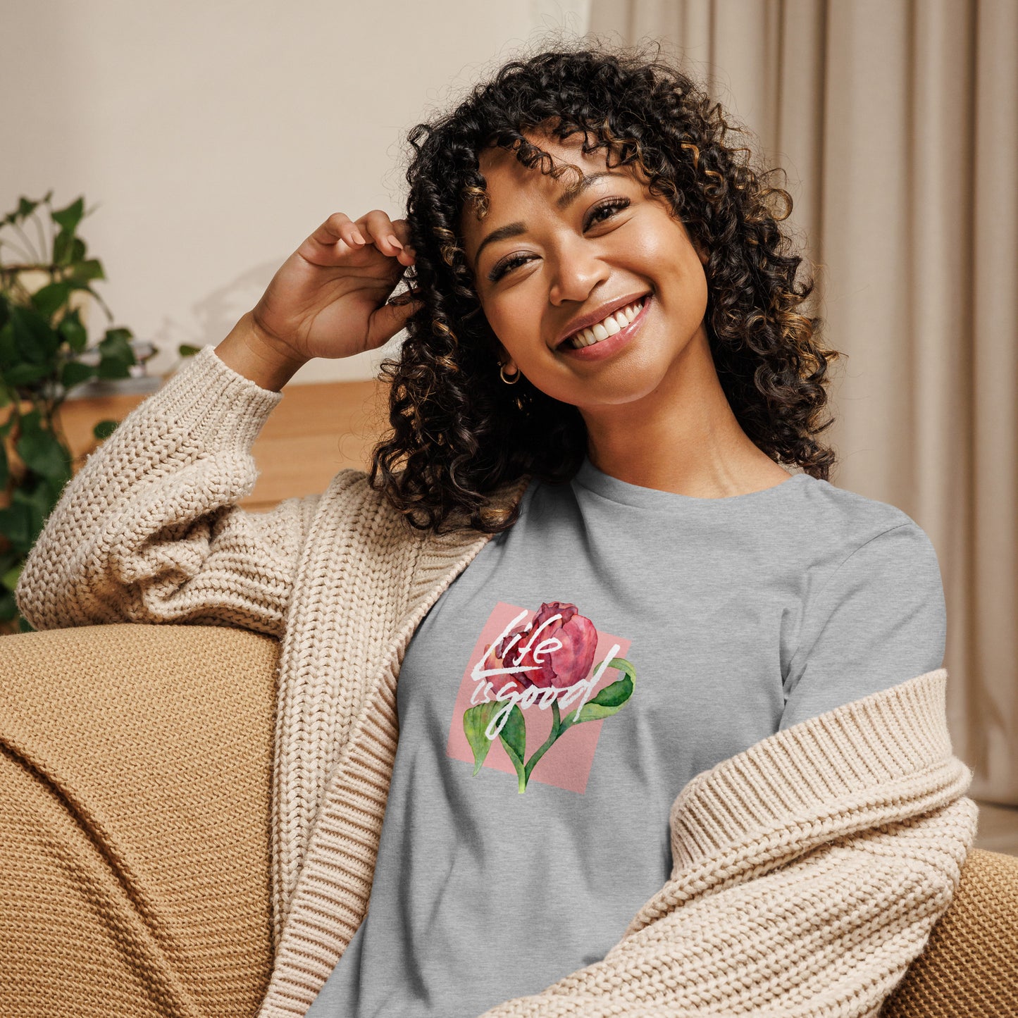 Woman smiling in a heather athletic grey relaxed t-shirt with colorful 'Life in Bloom' floral design