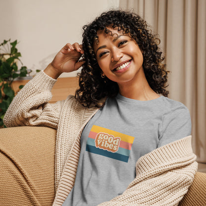 Woman smiling in a athletic heather grey relaxed t-shirt with colorful 'Good Vibes' graphic