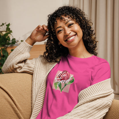 Woman smiling in a berry relaxed t-shirt with colorful 'Life in Bloom' floral design