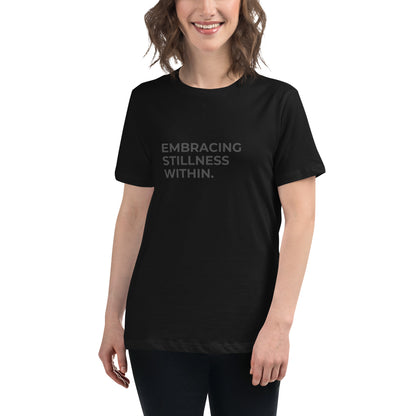 Woman wearing a black relaxed tee with "Embracing Stillness Within" printed.